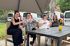 Vier Frauen sitzen an einem Tisch und trinken Wasser.
