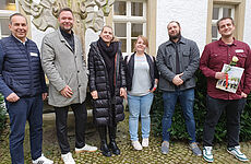 Vier Männer und zwei Frauen stehen nebeneinander.
