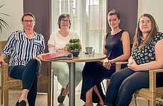 Vier Frauen sitzen an einem Tisch.