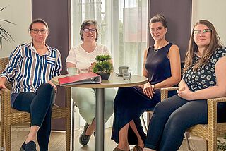 Vier Frauen sitzen an einem Tisch.