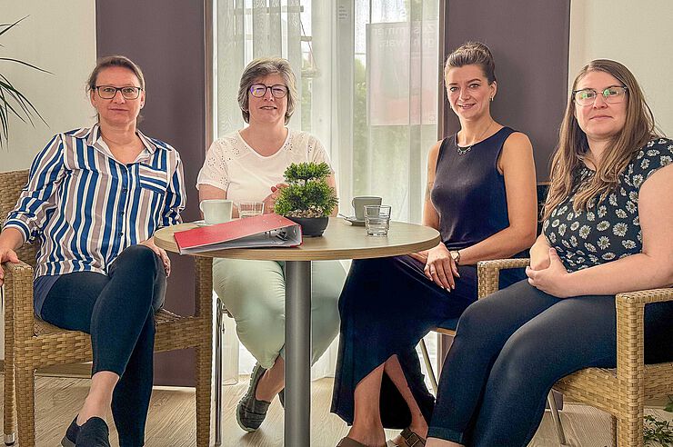 Vier Frauen sitzen an einem Tisch.
